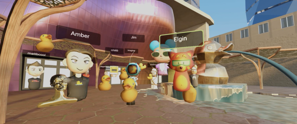 A gathering of Hubs avatars and duck mascots in a bright virtual plaza.
